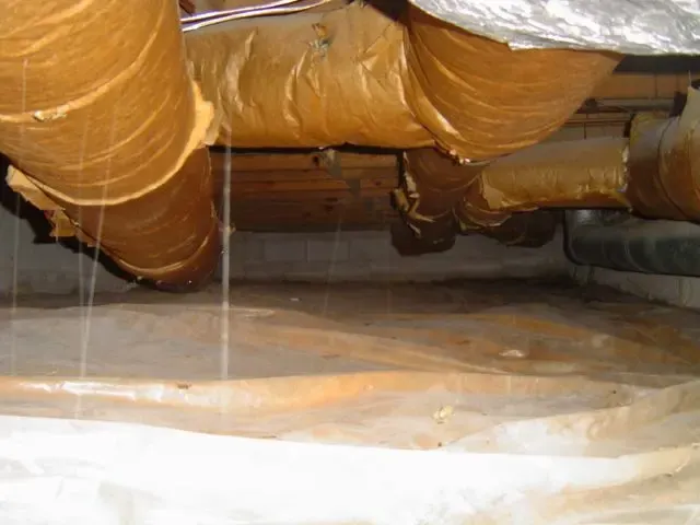 Water dripping from sweating HVAC ductwork onto a crawl space vapor barrier