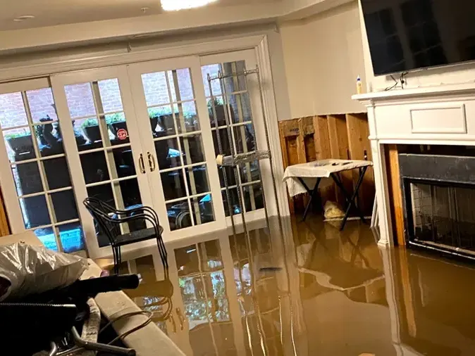 Muddy tropical storm floodwater covering a living room floor