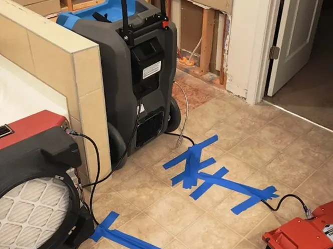 Air movers and a dehumidifier drying a flood-cut wall in Monroe, NC